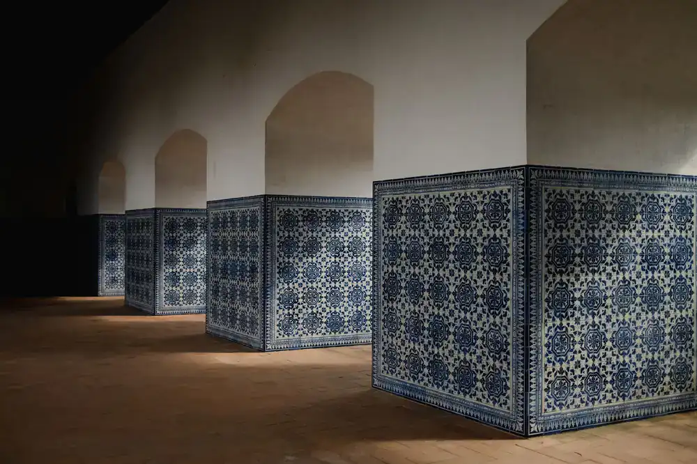 Close-up of a rich cobalt blue azulejo tile held by an artisan